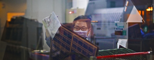 Working with a PCB in one of our factories | NCAB Group