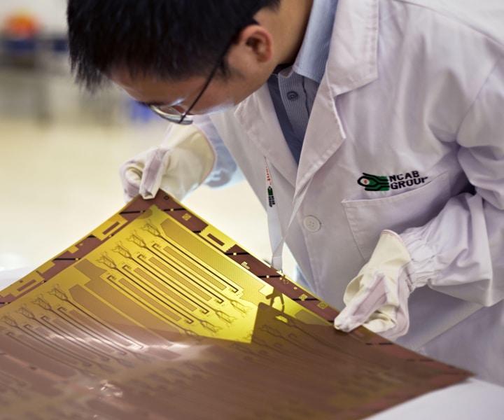 NCAB specialist with a printed circuit board (PCB) | NCAB Group